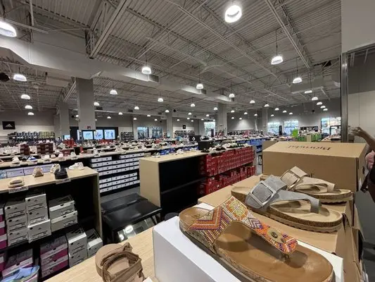 Off Broadway Shoes store featuring premium basketball shoes hiking boots and water shoes displayed on organized shelves with customers browsing athletic footwear
